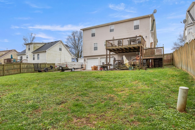 rear view of property with a garage, a yard, and a wooden deck