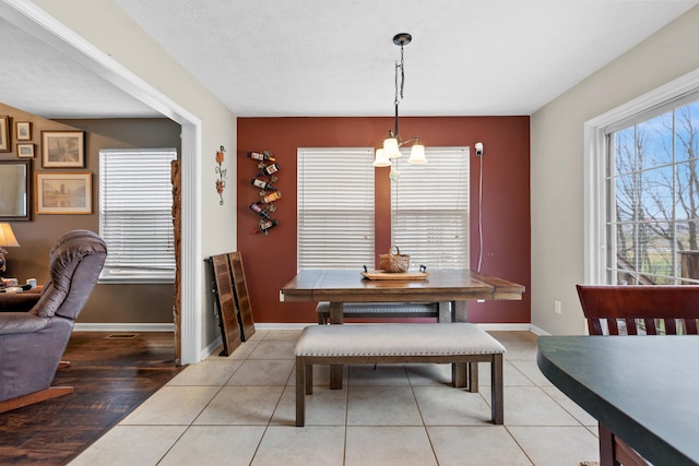 dining room featuring a textured ceiling, light hardwood / wood-style floors, and an inviting chandelier