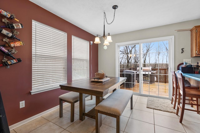 dining space with light tile patterned flooring and a notable chandelier