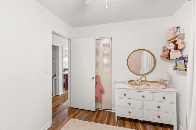 bedroom featuring a closet, dark hardwood / wood-style flooring, a textured ceiling, and sink