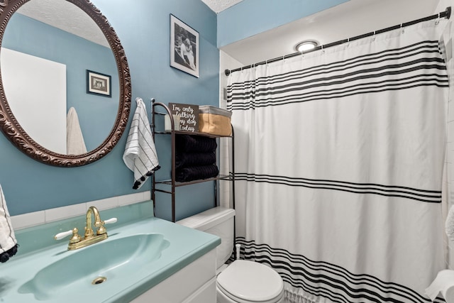 bathroom with vanity, a textured ceiling, and toilet