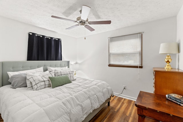 bedroom with ceiling fan, dark wood-type flooring, and a textured ceiling