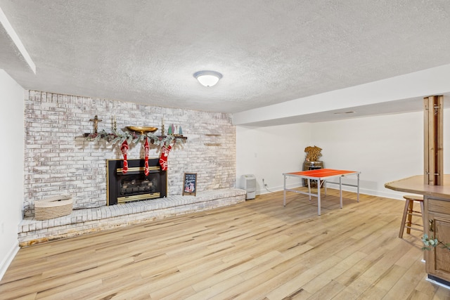 interior space featuring a fireplace, a textured ceiling, and hardwood / wood-style flooring