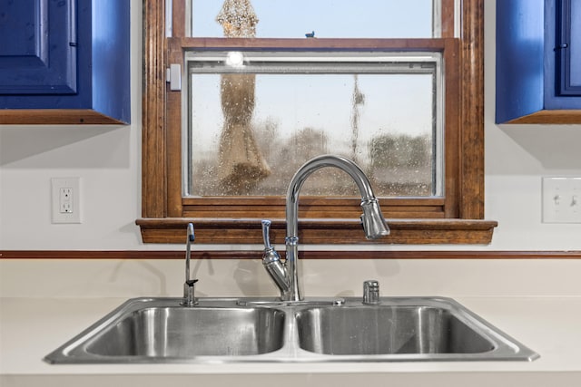 room details featuring blue cabinetry and sink