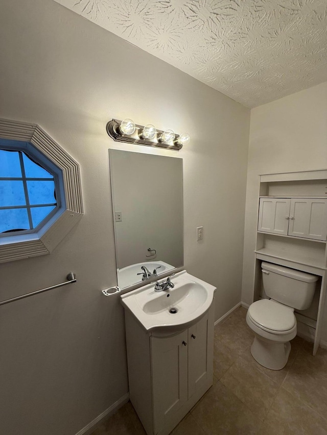 bathroom featuring tile patterned floors, vanity, a textured ceiling, and toilet