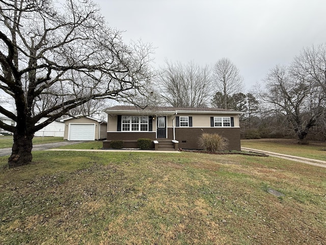 ranch-style home with an outbuilding, a front yard, and a garage