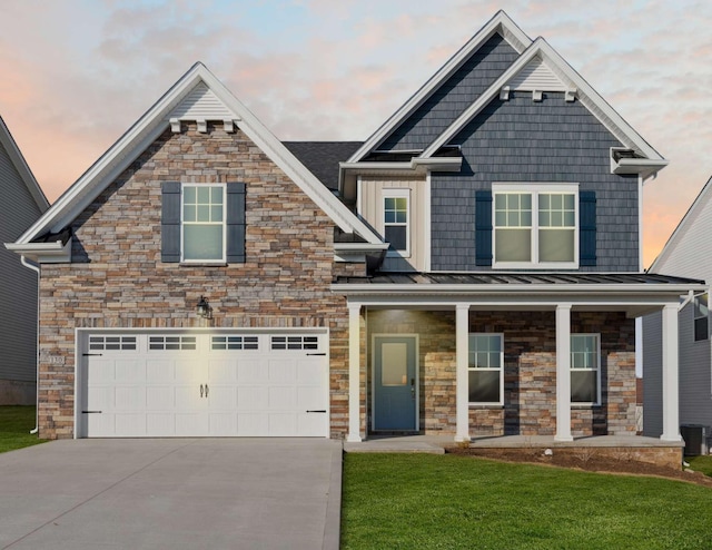 craftsman-style home featuring a yard, a porch, concrete driveway, a standing seam roof, and metal roof