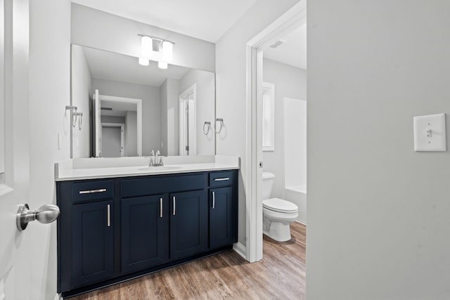 bathroom with vanity, wood-type flooring, and toilet