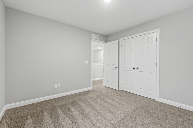 unfurnished bedroom with carpet and a closet