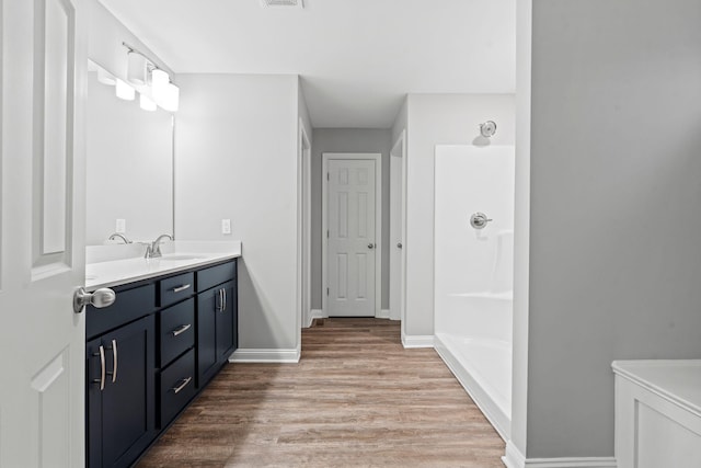 bathroom featuring vanity, hardwood / wood-style flooring, and walk in shower