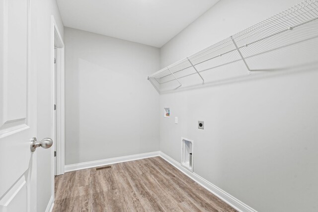 laundry room featuring hookup for an electric dryer, hookup for a washing machine, and light hardwood / wood-style flooring