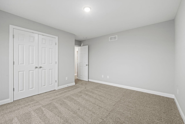 unfurnished bedroom featuring carpet flooring and a closet