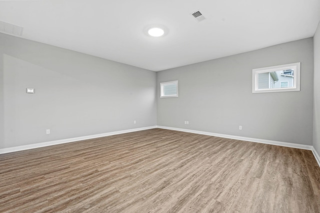 empty room featuring plenty of natural light and light hardwood / wood-style floors