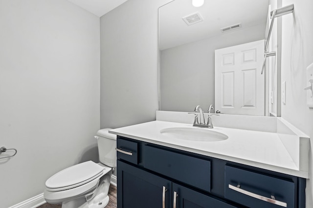 bathroom featuring wood-type flooring, vanity, and toilet