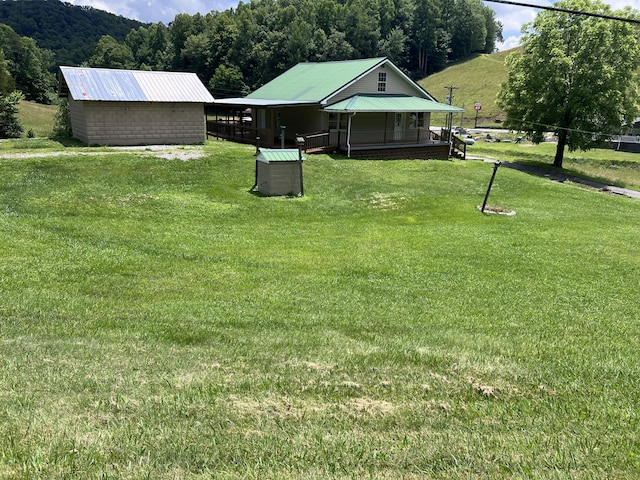 view of yard with a porch and an outdoor structure