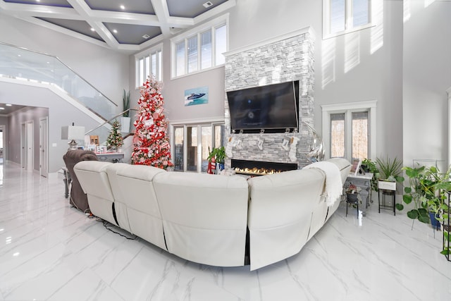 living room featuring a towering ceiling, a wealth of natural light, and coffered ceiling