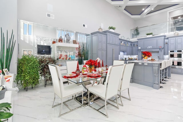 dining space with beam ceiling, a towering ceiling, and coffered ceiling