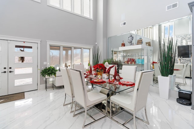 dining space with a towering ceiling