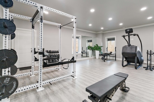 workout room featuring light wood-type flooring and ornamental molding