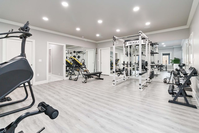 workout area with light hardwood / wood-style flooring and ornamental molding