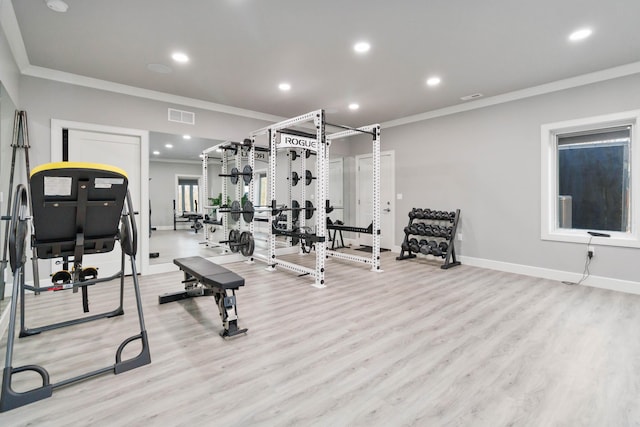 workout area with light hardwood / wood-style flooring and ornamental molding