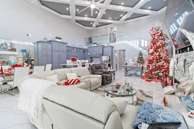 living room featuring beamed ceiling, a high ceiling, ceiling fan, and coffered ceiling