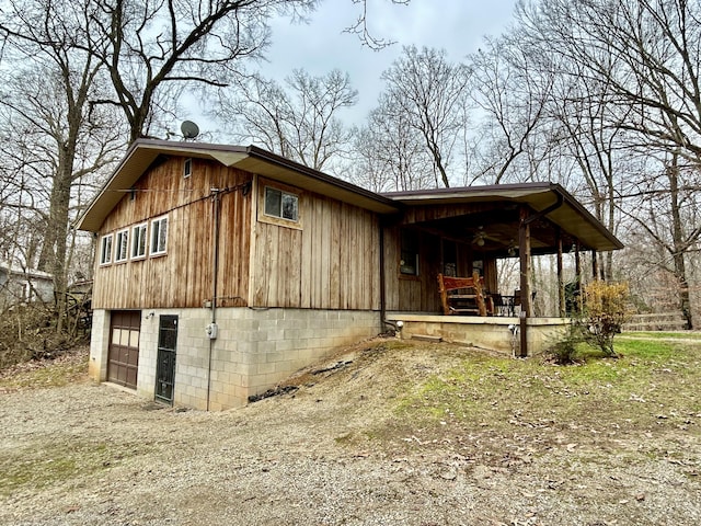 view of side of home featuring a garage and covered porch