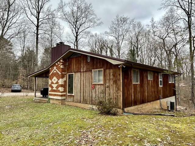 view of side of home featuring a lawn and central AC unit