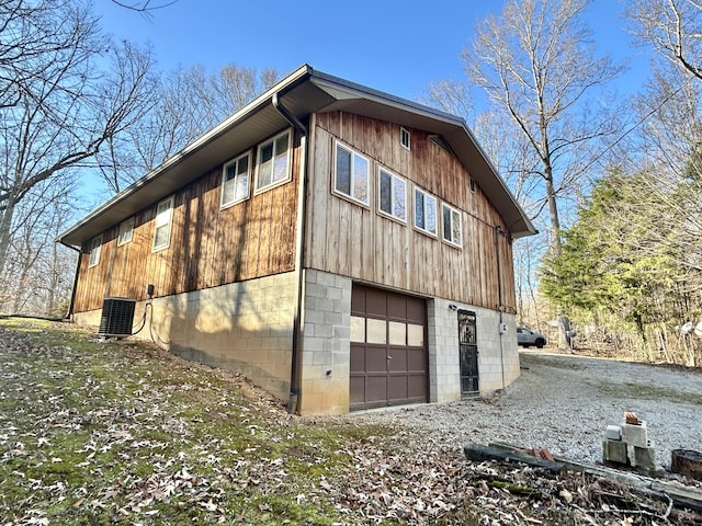 view of property exterior with a garage and central air condition unit