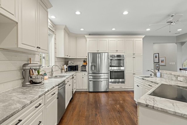 kitchen with dark wood-type flooring, sink, light stone counters, white cabinetry, and stainless steel appliances