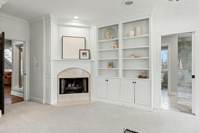 living room with light carpet, crown molding, and a high end fireplace