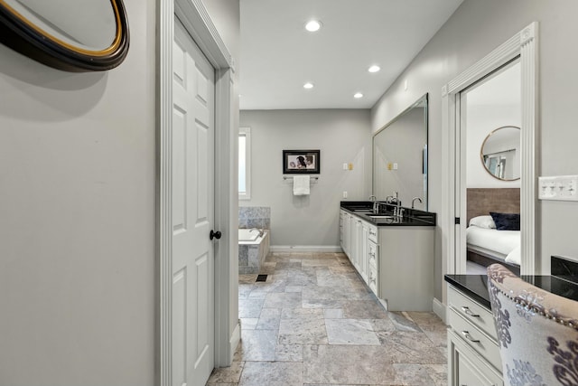 bathroom with vanity and tiled bath