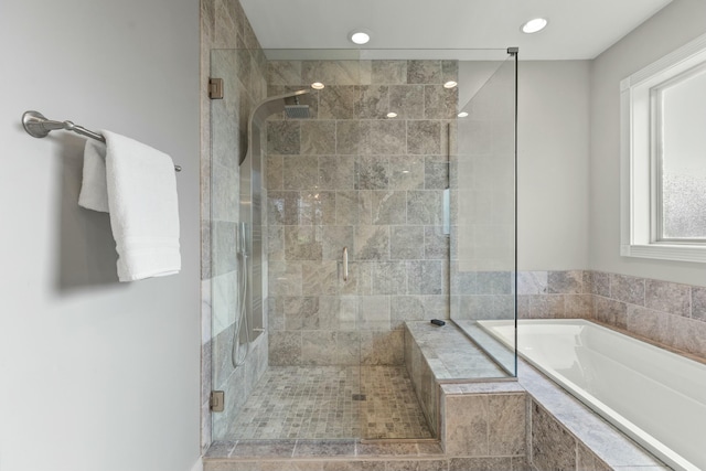 bathroom featuring shower with separate bathtub