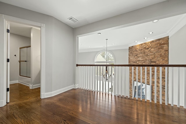 hallway featuring a notable chandelier, crown molding, and dark wood-type flooring