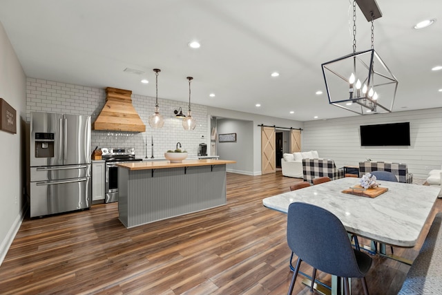 dining room with a barn door, dark hardwood / wood-style floors, and an inviting chandelier