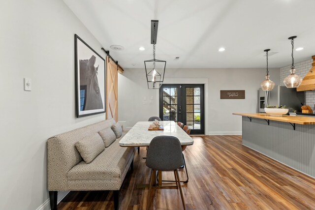 dining area featuring dark hardwood / wood-style floors, a barn door, and french doors