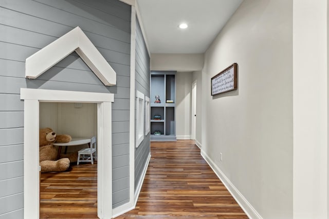 corridor with built in features and dark wood-type flooring