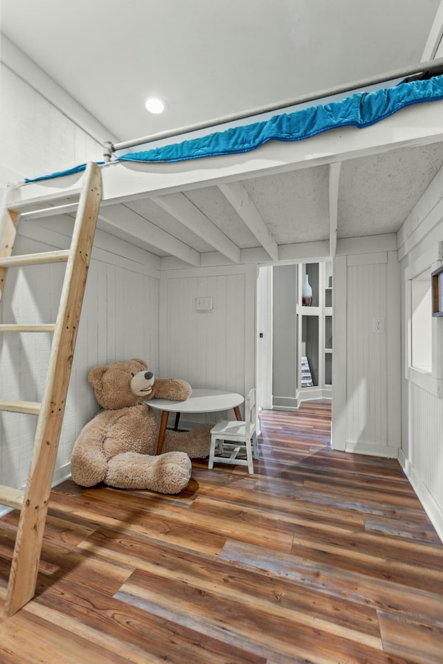 living area featuring beamed ceiling and wood-type flooring