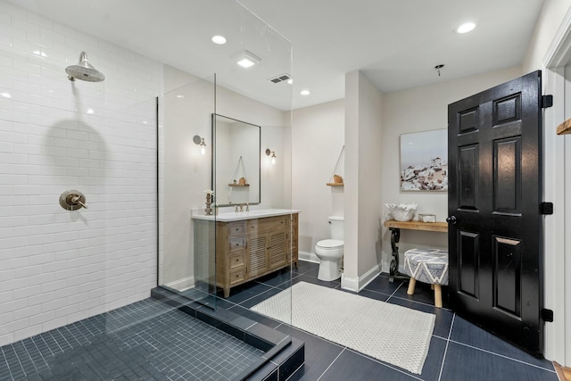 bathroom featuring tiled shower, vanity, tile patterned floors, and toilet