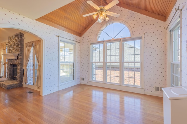 unfurnished living room featuring a stone fireplace, light hardwood / wood-style flooring, wooden ceiling, and lofted ceiling