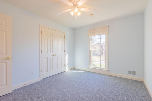 unfurnished bedroom with ceiling fan, carpet floors, and a closet