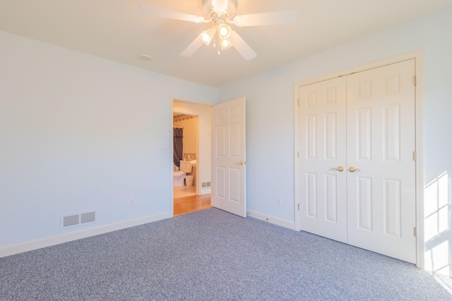 unfurnished bedroom featuring carpet, ceiling fan, and a closet