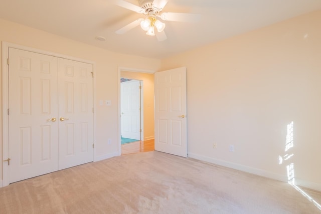 unfurnished bedroom with light carpet, a closet, and ceiling fan