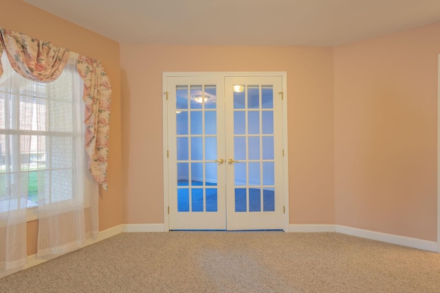 carpeted spare room featuring french doors