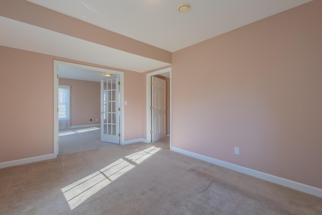 empty room featuring light carpet and french doors