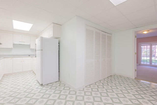 kitchen featuring a paneled ceiling, white fridge, white cabinetry, and french doors