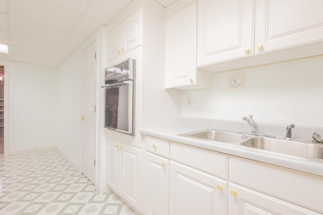 kitchen featuring white cabinets, sink, and oven