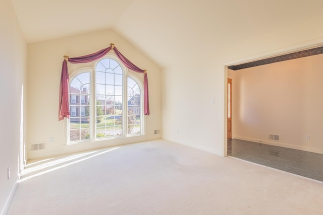 carpeted empty room featuring lofted ceiling