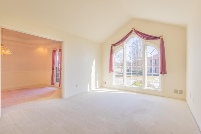 carpeted empty room featuring vaulted ceiling