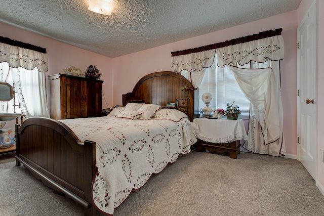 bedroom with multiple windows, carpet, and a textured ceiling